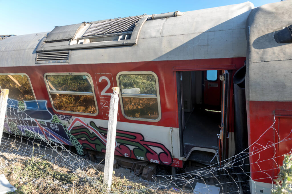 Abandoned train car with graffiti near a fence