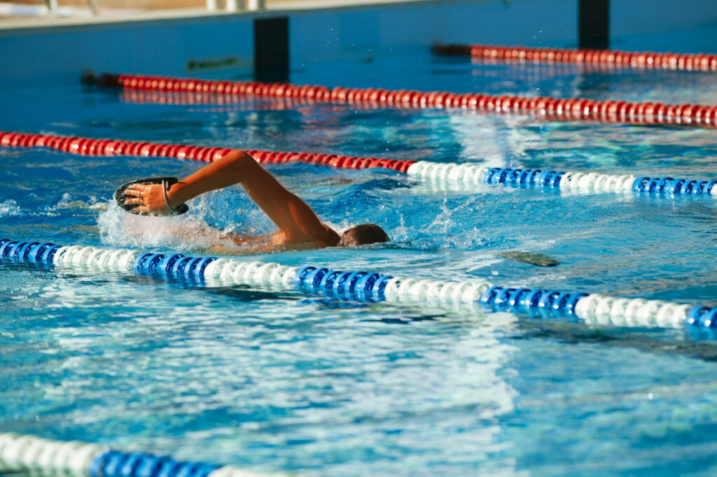 Swimmer practicing freestyle stroke in a pool lane.